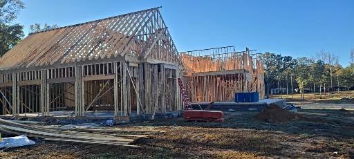 Framing a custom home in Cullman, AL, with roof trusses and studs in place. See average prices, labor, materials, and ways to save on your build.