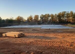 Concrete slab foundation pour on a Smith Lake AL waterfront lot with crew and pump truck, showing costs for slabs versus pier and beam in 2025. Schedule a Free Estimate.