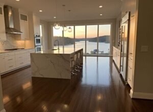 Hardwood floor installation in a modern white kitchen overlooking Smith Lake in Cullman, Alabama.