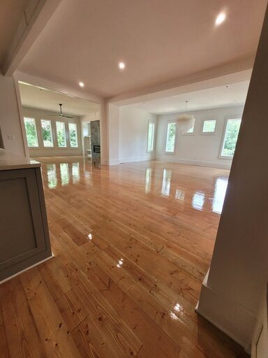 Freshly installed hardwood floors in an open-concept living and dining room in a Cullman, Alabama home.