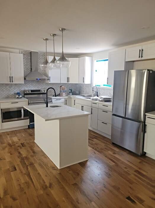 Kitchen remodel in Cullman AL with new cabinets, island, and hardwood flooring installed by Hunter’s Ridge Construction.