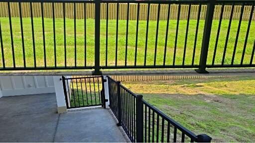 Black metal railing and gate along concrete patio and stairs at a Cullman AL home, showing safe access from porch to backyard