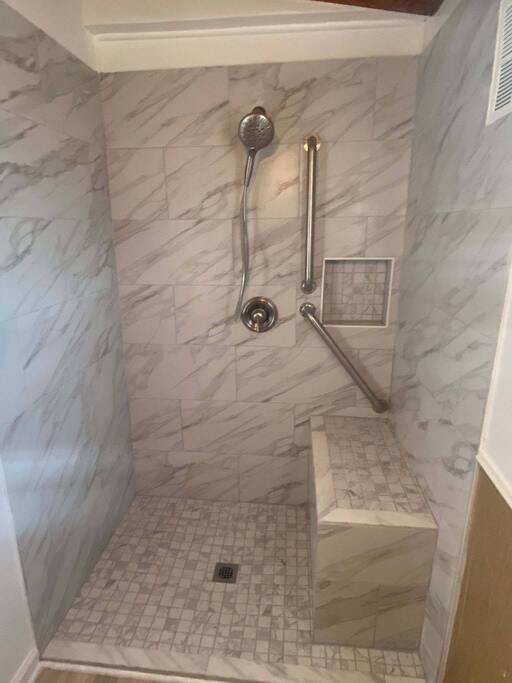 Walk-in shower remodel with tile walls, bench seat, niche, and grab bars in a Cullman and Smith Lake AL home.