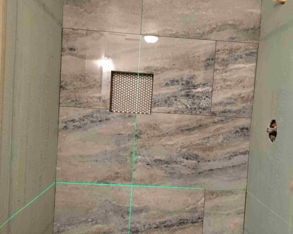 During: shower tile layout in progress using a laser line and niche detail