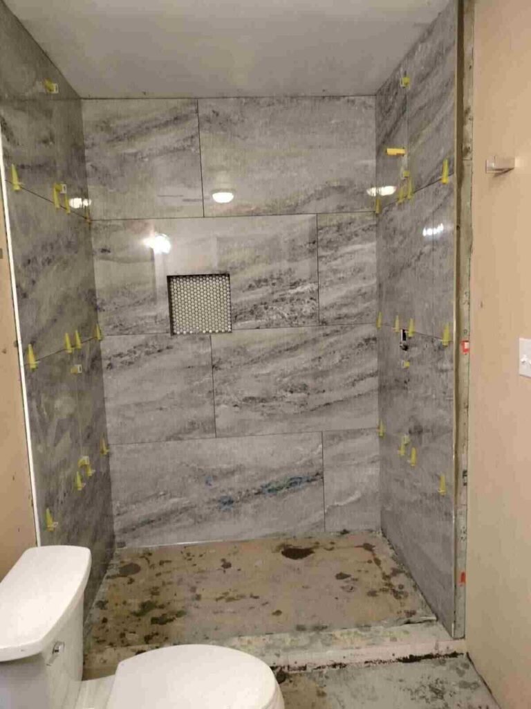 During: shower tile installation in progress with spacers and niche opening