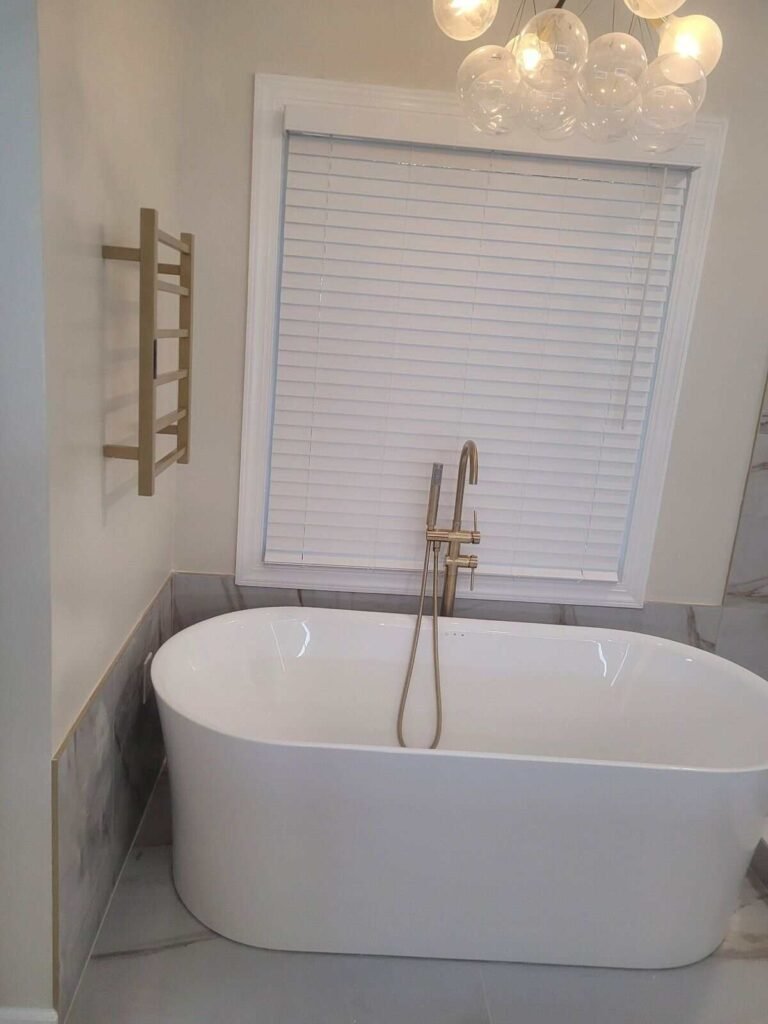 Freestanding tub detail in a finished Mountain Brook 35223 bathroom remodel with brass fixtures