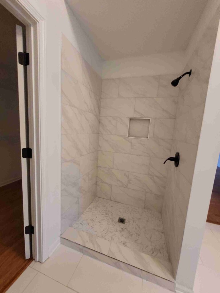 Finished walk-in shower remodel in Mountain Brook 35223 with marble-look tile and matte black fixtures