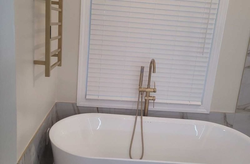 Finished freestanding tub with tile surround and towel rack