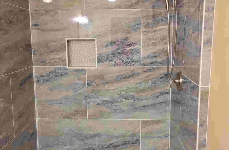 Finished tile shower remodel with large format tile and niche